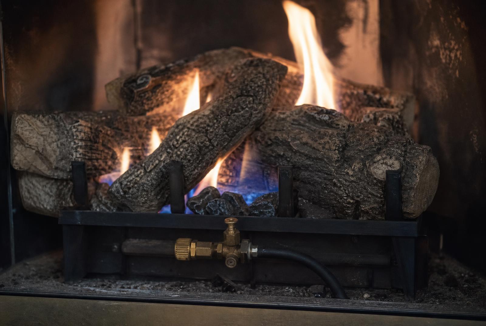 Gas fireplace with logs burning in a living room